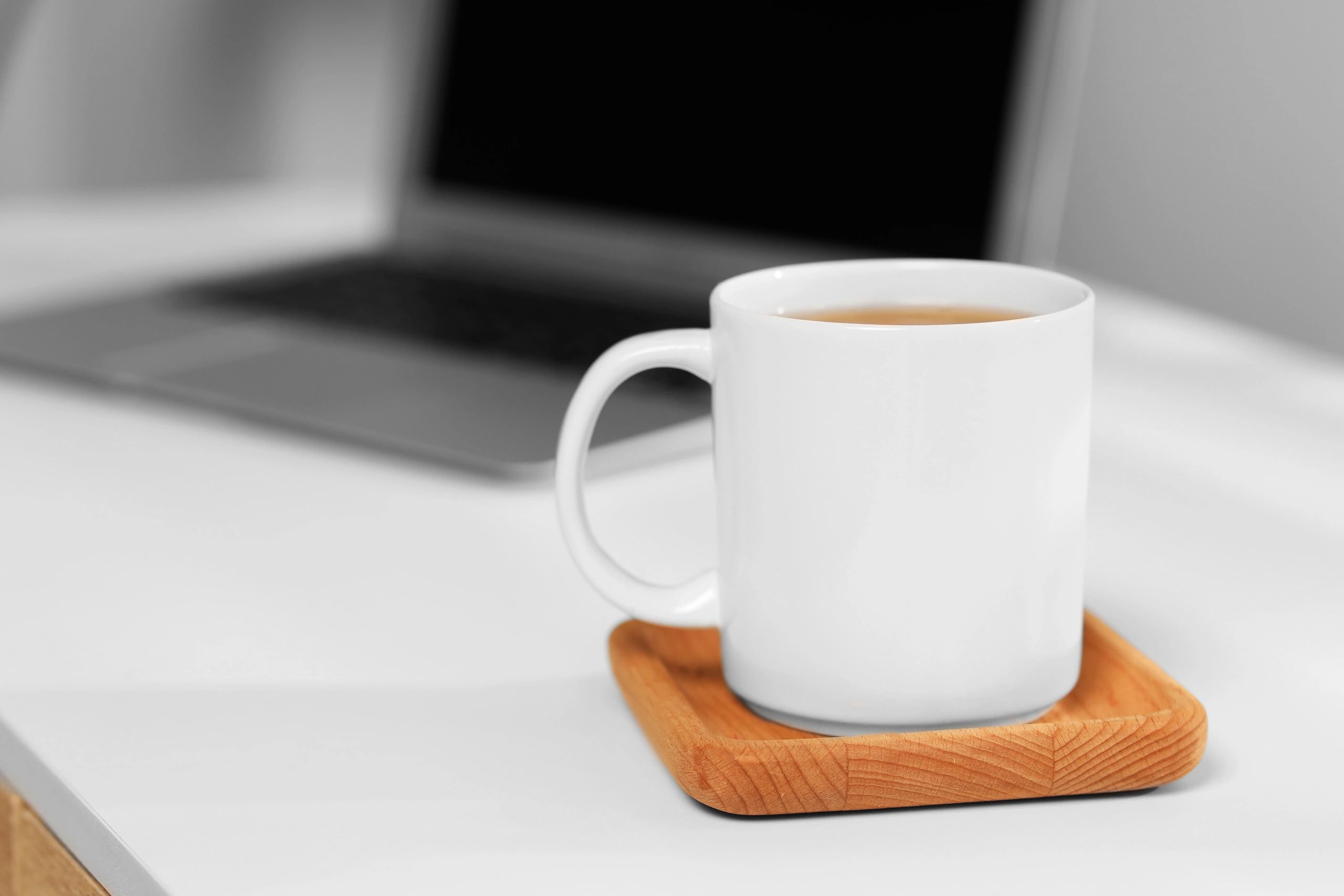 White mug on a workplace table with space for text
