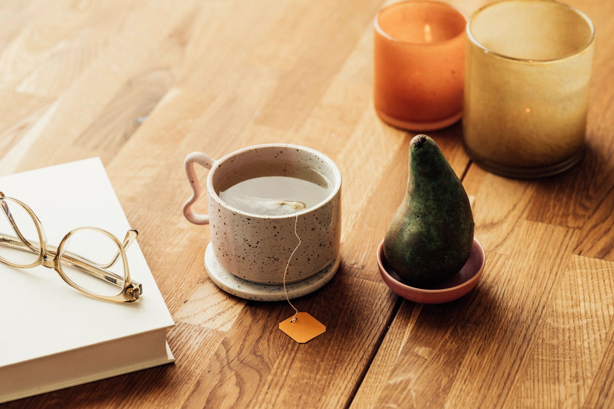 Warm tea on a table with a book and candles